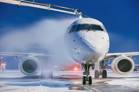 Winter morning at airport. Deicing of airplane before flight.