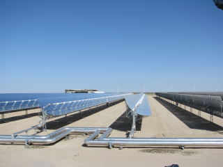 Figure 3. Part of the 50-MW concentrated solar power (CSP) plant at the Shagaya Renewable Energy Park in western Kuwait, with the new KISR research facility and the wind turbines in the background.